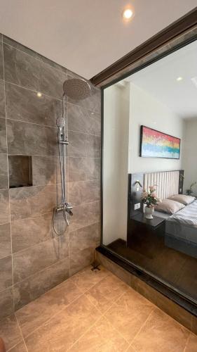 a bathroom with a shower and a bedroom with a bed at Studio Sapphire Hạ Long View Biển in Ha Long