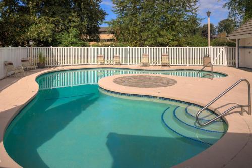 a large swimming pool with chairs and a fence at Residence Inn Seattle South/Tukwila in Tukwila