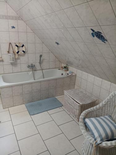a bathroom with a tub and a chair next to a bath tub at Zum Graureiher in Heringsdorf