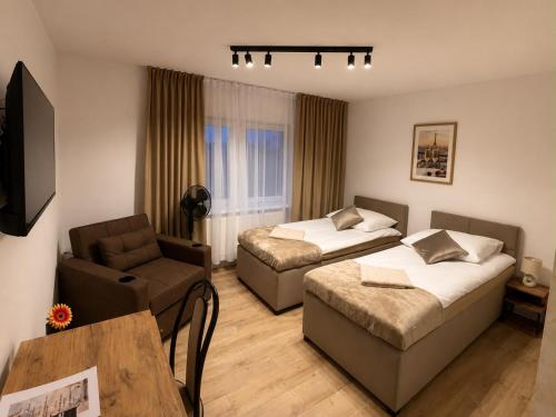 a hotel room with two beds and a couch at Apartament i pokoje Szalawa in Kalisz