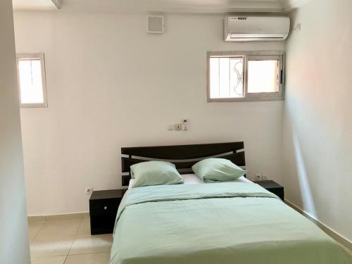 a bedroom with a bed with two pillows on it at Villa Terracotta - Riviera Synacassi - 3 chambres in Abidjan