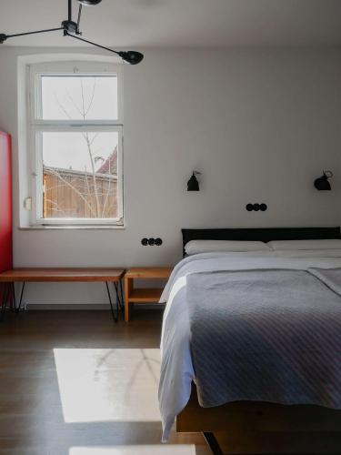 a white bedroom with a bed and a window at Das Bauhaus-Eck in Dobritz