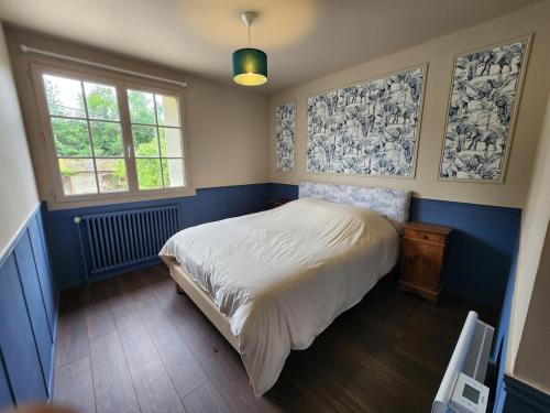 a bedroom with a white bed and two windows at La Pastellière - Combrand in Combrand