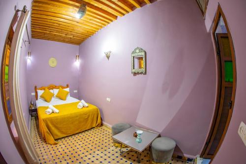 a small room with a bed and a table in it at Riad Mozaik Fes in Fez