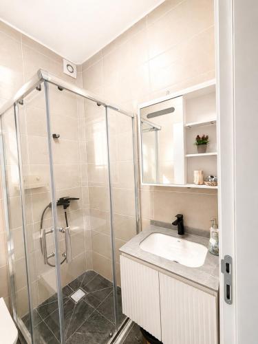 a bathroom with a glass shower and a sink at MangaRenga apartments in Šušanj