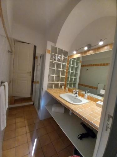 a bathroom with a sink and a mirror at Hotel de la Plage in Le Lavandou