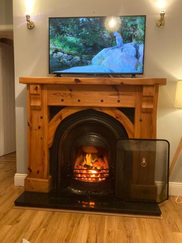 a fireplace with a television on top of it at Butterfly cottage in Belmullet