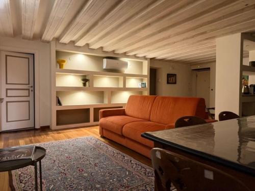 a living room with an orange couch and a table at Luxury Cernaia Home alloggio di charme nel Centro Storico in Genoa