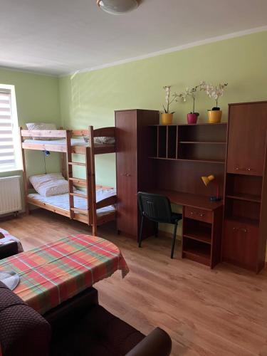 ein Zimmer mit zwei Etagenbetten und einem Schreibtisch und einem Schreibtisch in der Unterkunft Arkadiusz in Tarnobrzeg