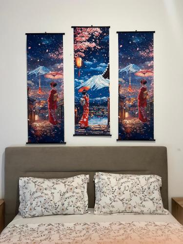 four paintings on a wall above a bed at becici residance with pool & sauna in Budva