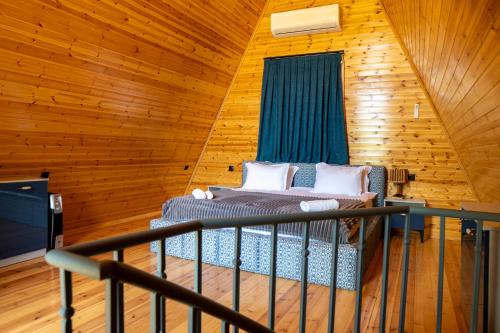 a bedroom with a bed in a wooden cabin at SaguleResort in Monasteri
