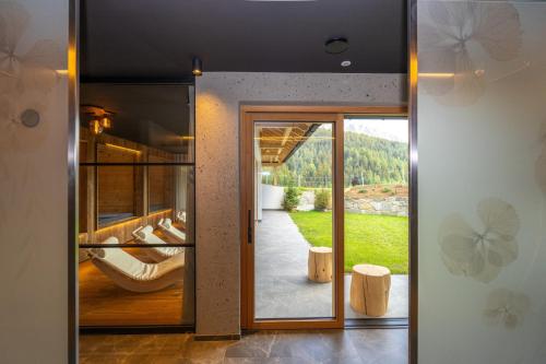 a glass door leading into a house with a view at Altmessnerhof in Dobbiaco