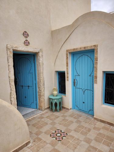 two blue doors in a room with a tile floor at Houch traditionnelle in Houmt Souk