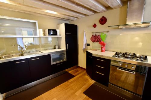 a kitchen with a sink and a stove top oven at Luxury Cernaia Home alloggio di charme nel Centro Storico in Genoa