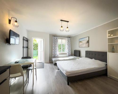 a bedroom with two beds and a desk in it at Morena in Jarosławiec