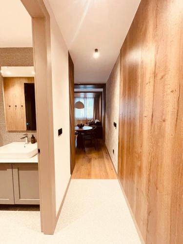 a hallway leading to a kitchen with a sink and a table at Apartman 206 in Jahorina