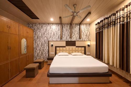 a bedroom with a bed and a ceiling fan at Mona's Villa Homestay in Dharmsāla
