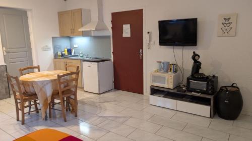 a kitchen with a table and a kitchen with a microwave at Studio tout confort in Le Fossat