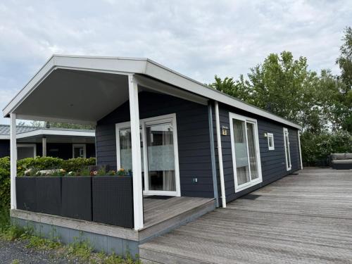 a black house with a porch and a deck at Natuurhuisje Abcoude - De Smient - Best Family Stay in Abcoude