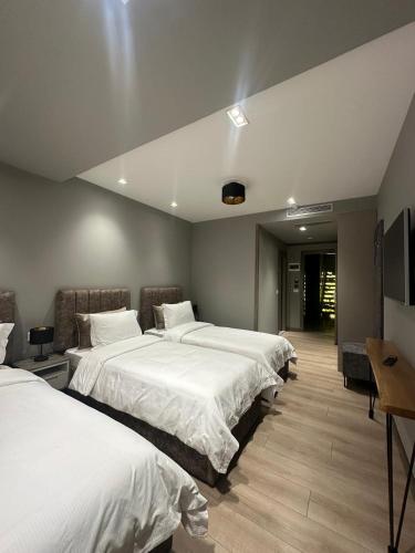 a hotel room with two beds and a television at Hotel EIBA in Peshkopi