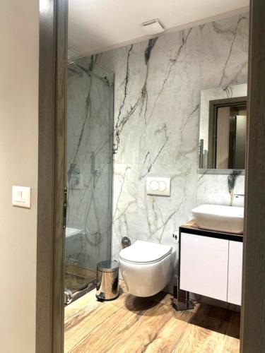 a bathroom with a toilet and a sink and a shower at Hotel EIBA in Peshkopi