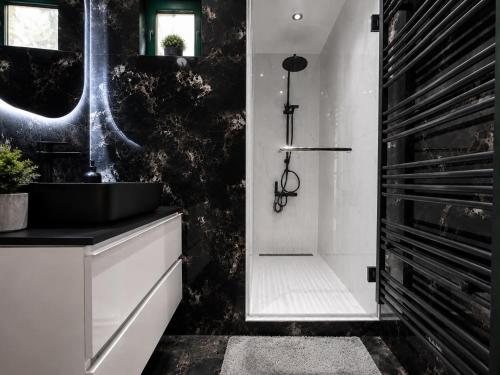 a black and white bathroom with a sink and a shower at L'aTTIQUE in Kastanéa