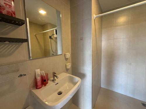 a white bathroom with a sink and a shower at Vay Pothisan in North Pattaya