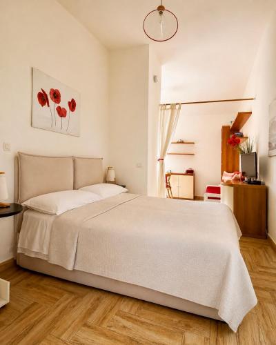 a bedroom with a large white bed and wooden floors at West Sardinia - Bosa in Magomadas