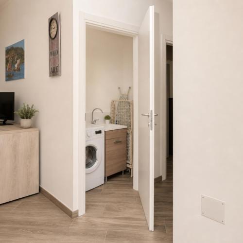 a laundry room with a washing machine and a sink at Sa lampana in Orosei