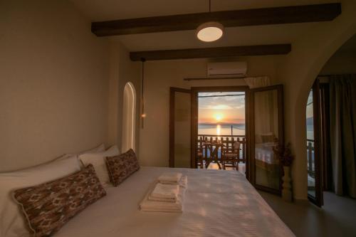 ein Schlafzimmer mit einem Bett und Meerblick in der Unterkunft ARGO Luxury Suites in Milína