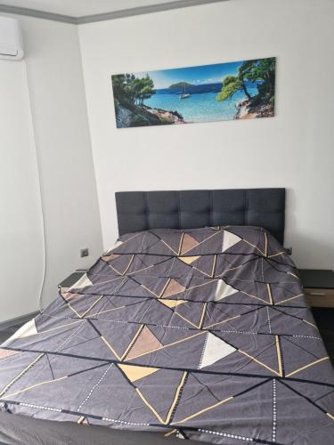 ein Schlafzimmer mit einem Bett, auf dem eine Steppdecke liegt in der Unterkunft Dan-Mari in Baltschik