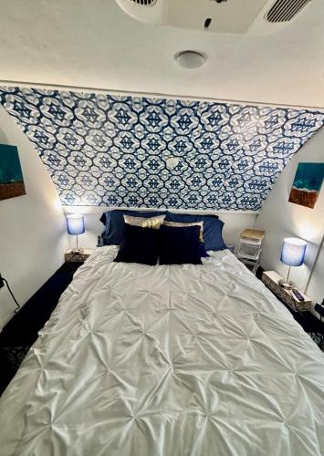 a bedroom with a large bed with a blue and white wall at Hidden Anchor in Burton