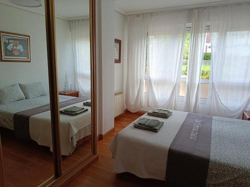a bedroom with two beds and a mirror at La Terrazuca in Santander