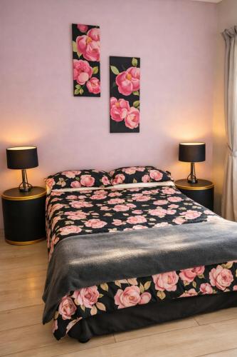 a bedroom with a bed with pink flowers on it at Garden Route Retreat in George