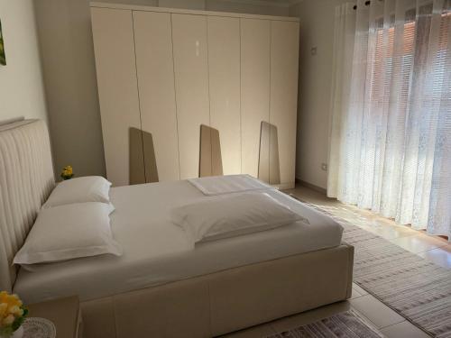 a large white bed in a room with a window at Panoramic Krujë Escape BAMI in Krujë