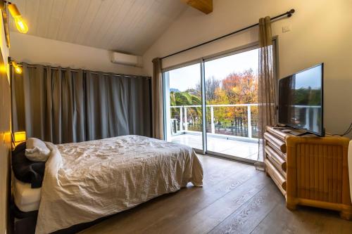 a bedroom with a bed and a large window at villa avec piscine in Hendaye