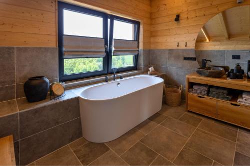 a bath tub in a bathroom with a window at Bayerwald Chalet Liebenstein in Bad Koetzting