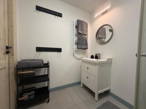 a white bathroom with a sink and a mirror at Sunset House Svencele in Svencelė