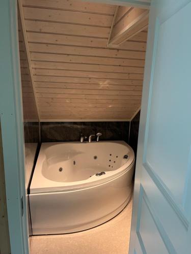 a bath tub in a room with a wooden ceiling at Feriehus Lærdal in Æri
