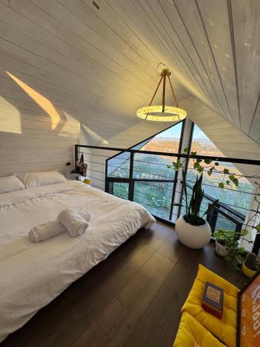 a bedroom with a large bed and a large window at Yellow House Natakhtari in Mtskheta