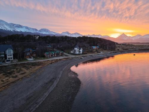 a sunset over a beach with a body of water at COSTA DE LOS PAJAROS in Ushuaia