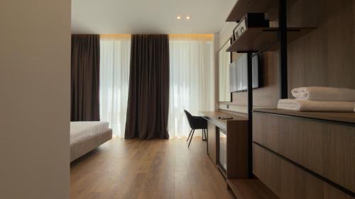 a hotel room with a bed and a desk and a window at Art Hotel Vlora in Vlorë