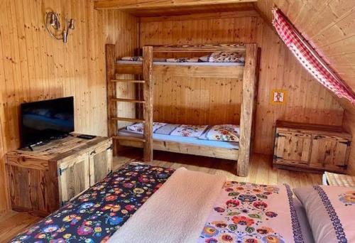 a room with two bunk beds and a television at Chata Reľov in Reľov