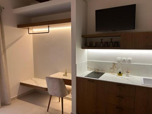 eine Küche mit Spüle und einem Schreibtisch mit Stuhl in der Unterkunft ARGO Luxury Suites in Milína