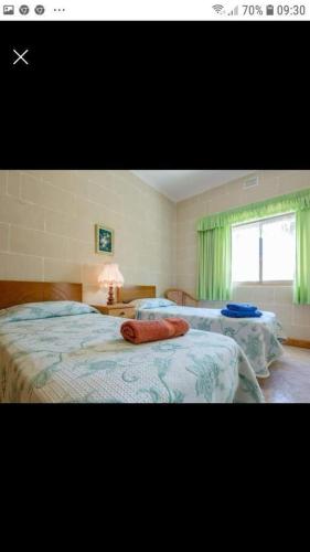 a bedroom with two beds and a window at Gozo Apartment - Sannat in Sannat