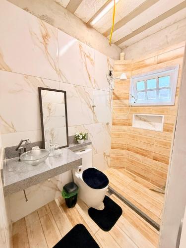 a bathroom with a toilet and a sink at Zion Cottage in Paraty