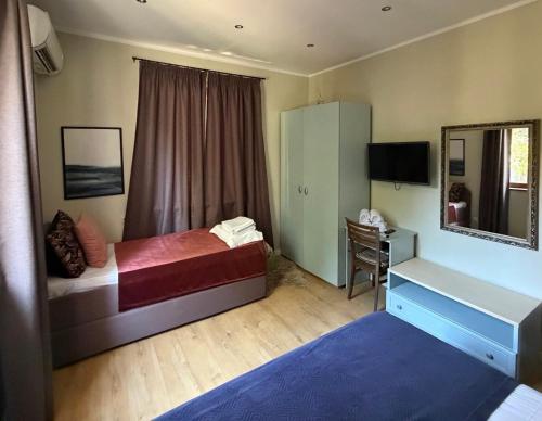 a bedroom with a bed and a desk and a mirror at Charisma in Haskovo