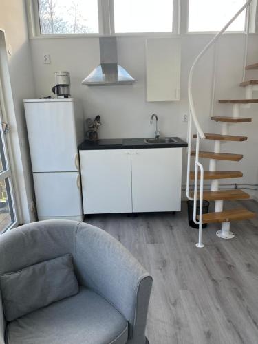 a living room with a couch and a staircase at Stuga 2 Björkeslund in Veberöd