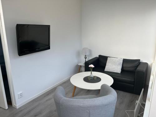 a living room with a couch and a table at Stuga 2 Björkeslund in Veberöd