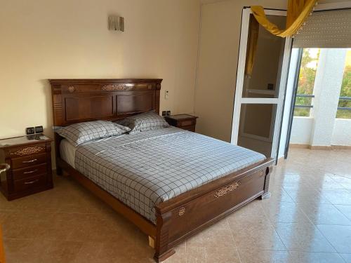 a bedroom with a bed and a dresser and a window at Villa Perle Bleu in Saïdia